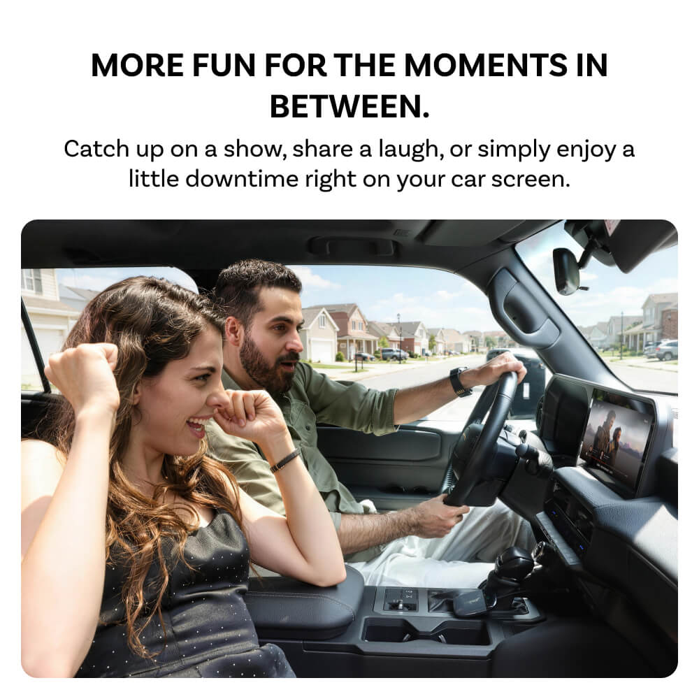 Promotional graphic with text reading 'MORE FUN FOR THE MOMENTS IN BETWEEN.' above a photo of a man driving a car and a woman smiling in the passenger seat, with a car display screen showing content.